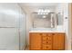 Bright bathroom featuring a glass shower stall and a wood vanity with a rectangular framed mirror above it at 3088 Bicentennial Pkwy, Henderson, NV 89044