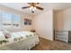 Cozy bedroom featuring a ceiling fan, a large window with shutters, and colorful artwork at 3088 Bicentennial Pkwy, Henderson, NV 89044