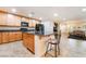 Open kitchen boasts wood cabinets, granite countertops, and an eat-in island at 3088 Bicentennial Pkwy, Henderson, NV 89044