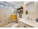 Bright bathroom with vanity and storage, shower over bath and modern fixtures at 3257 River Glorious Ln, Las Vegas, NV 89135