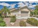 Inviting single-story home with a well-maintained lawn, desert landscaping, and an attached two-car garage at 3257 River Glorious Ln, Las Vegas, NV 89135