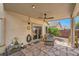 Covered patio with stone flooring, ceiling fan, and comfortable seating area at 3257 River Glorious Ln, Las Vegas, NV 89135