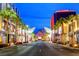 A beautiful street view at night lined with palm trees and retail stores at 3257 River Glorious Ln, Las Vegas, NV 89135