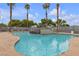 Community pool with surrounding lounge chairs and tall palm trees at 3318 N Decatur Blvd # 1043, Las Vegas, NV 89130