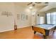 A spacious game room features an elegant pool table, ceiling fan, and gleaming wood floors at 3432 Beca Faith Dr, North Las Vegas, NV 89032