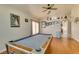 A spacious game room features an elegant pool table, ceiling fan, and gleaming wood floors at 3432 Beca Faith Dr, North Las Vegas, NV 89032