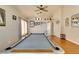 A spacious game room features an elegant pool table, ceiling fan, and gleaming wood floors at 3432 Beca Faith Dr, North Las Vegas, NV 89032
