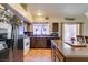 Lovely kitchen featuring warm wood cabinetry, tile backsplash, and a view into the dining area at 3432 Beca Faith Dr, North Las Vegas, NV 89032
