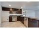 Modern kitchen features dark wood cabinets, stainless steel appliances, and granite countertops at 345 Gracious Way, Henderson, NV 89011