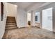 Open living room with plush carpeting, staircase, and access to bathroom and laundry room at 345 Gracious Way, Henderson, NV 89011