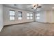 Spacious living room featuring a ceiling fan, carpet, and multiple windows at 345 Gracious Way, Henderson, NV 89011