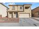 Home's exterior with desert landscaping, covered porch, and a two-car garage; a blend of comfort and style at 3532 Carisbrook Dr, North Las Vegas, NV 89081