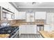 Well-lit kitchen featuring white cabinets, granite countertops, stainless steel appliances, and a mosaic backsplash at 3532 Carisbrook Dr, North Las Vegas, NV 89081