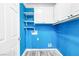 Laundry room showcasing bright blue walls, white shelving, and cabinetry at 3532 Carisbrook Dr, North Las Vegas, NV 89081