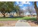 Inviting community park with walking path, mature trees, and a bench for relaxation at 3532 Carisbrook Dr, North Las Vegas, NV 89081