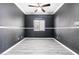 Personal Cave featuring gray wood floors, dark walls, crown molding, and ceiling fan at 3532 Carisbrook Dr, North Las Vegas, NV 89081
