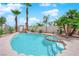 Inviting backyard pool with rock features, steps into the pool, and mature palm trees for a tropical oasis at 3592 N Campbell Rd, Las Vegas, NV 89129