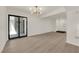 Open living space with sliding glass door, wood flooring, and contemporary lighting at 3667 Mckinley Ave, Las Vegas, NV 89121