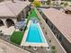 Aerial view of a backyard featuring a pool, landscaping, a stone wall, and neighboring homes at 38 Costa Tropical Dr, Henderson, NV 89011