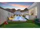 Beautiful backyard featuring pool, putting green, and outdoor entertaining area with mountain views at 38 Costa Tropical Dr, Henderson, NV 89011