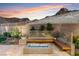 Inviting backyard seating area features a modern fire pit and integrated bench seating at 38 Costa Tropical Dr, Henderson, NV 89011
