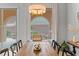 Bright dining room with wood table, modern chandelier, and a large window overlooking the landscaped backyard at 38 Costa Tropical Dr, Henderson, NV 89011