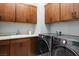 Efficient laundry room with sleek washer and dryer, ample cabinetry, and a sink for added convenience at 38 Costa Tropical Dr, Henderson, NV 89011