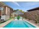 Stunning pool area with in-pool lounge chairs, striped umbrellas, and lush landscaping for a resort-like feel at 38 Costa Tropical Dr, Henderson, NV 89011