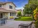 A cozy backyard patio with furniture and lush green lawn and colorful flowering shrubs at 390 Rushing Creek Ct, Henderson, NV 89014