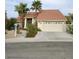 Charming home showcasing a well-manicured yard with palm trees and a two-car garage at 390 Rushing Creek Ct, Henderson, NV 89014