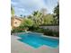 Backyard pool with tiled accents, surrounded by mature trees and a privacy fence at 390 Rushing Creek Ct, Henderson, NV 89014