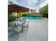 Backyard pool featuring lounge chairs, patio seating and a privacy fence surrounded by palm trees at 390 Rushing Creek Ct, Henderson, NV 89014