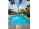 Sparkling backyard pool with tiled accents, surrounded by lush landscaping and lounge chairs at 390 Rushing Creek Ct, Henderson, NV 89014