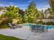 Inviting pool area with lounge chairs and dining set against a backdrop of lush greenery at 390 Rushing Creek Ct, Henderson, NV 89014