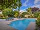 Sparkling swimming pool surrounded by a spacious patio, greenery, and lounge furniture at 390 Rushing Creek Ct, Henderson, NV 89014