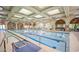 Stunning indoor pool area with arched windows, elegant lighting, and accessible ramp for a luxurious swimming experience at 4565 Riva De Romanza St, Las Vegas, NV 89135