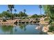 Beautiful community pond with waterfalls, lush landscaping, and palm trees at 4565 Riva De Romanza St, Las Vegas, NV 89135