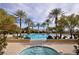 Inviting community pool area featuring a sparkling pool, hot tub, palm trees, and comfortable lounge seating at 4565 Riva De Romanza St, Las Vegas, NV 89135