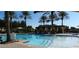 Community pool with lounge seating, palm trees, and a clear blue sky at 4565 Riva De Romanza St, Las Vegas, NV 89135