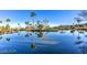 Scenic community waterfront featuring calm water, lush greenery, and picturesque palm trees reflected in the water at 4565 Riva De Romanza St, Las Vegas, NV 89135