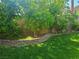 Well-maintained backyard with lush green lawn, mature trees, and brick-lined garden beds at 5305 Bright Sun Ct, Las Vegas, NV 89130