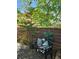 Landscaped patio featuring a decorative bench with pillows near trees and a brick wall at 5305 Bright Sun Ct, Las Vegas, NV 89130