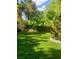 Beautifully landscaped backyard with manicured lawn, shade trees, and stone accents creating a serene outdoor space at 5305 Bright Sun Ct, Las Vegas, NV 89130