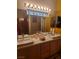 Bright bathroom with double sinks, large mirror, overhead lighting and yellow walls at 5305 Bright Sun Ct, Las Vegas, NV 89130