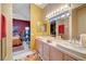 Bright bathroom featuring double sinks, decorative mirror, and adjacent bedroom view at 5305 Bright Sun Ct, Las Vegas, NV 89130
