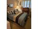 Comfortable bedroom featuring a queen-sized bed with blue and brown bedding, and natural light at 5305 Bright Sun Ct, Las Vegas, NV 89130