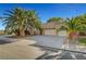Spacious home with a three-car garage, desert landscaping and mature palm trees at 5305 Bright Sun Ct, Las Vegas, NV 89130