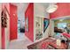 Bright hallway with red accent wall, modern chandelier, and views to kitchen, bathroom, and bedroom at 5305 Bright Sun Ct, Las Vegas, NV 89130