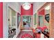 Hallway with bathroom and bedroom access, featuring a red accent wall and a modern chandelier at 5305 Bright Sun Ct, Las Vegas, NV 89130