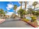 Community entrance with gate, landscaping, and palm trees at 5330 E Charleston Blvd # 28, Las Vegas, NV 89142